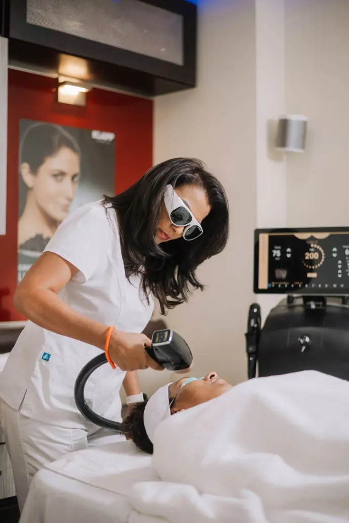 Certified aesthetician performing advanced laser treatment in Port of Spain